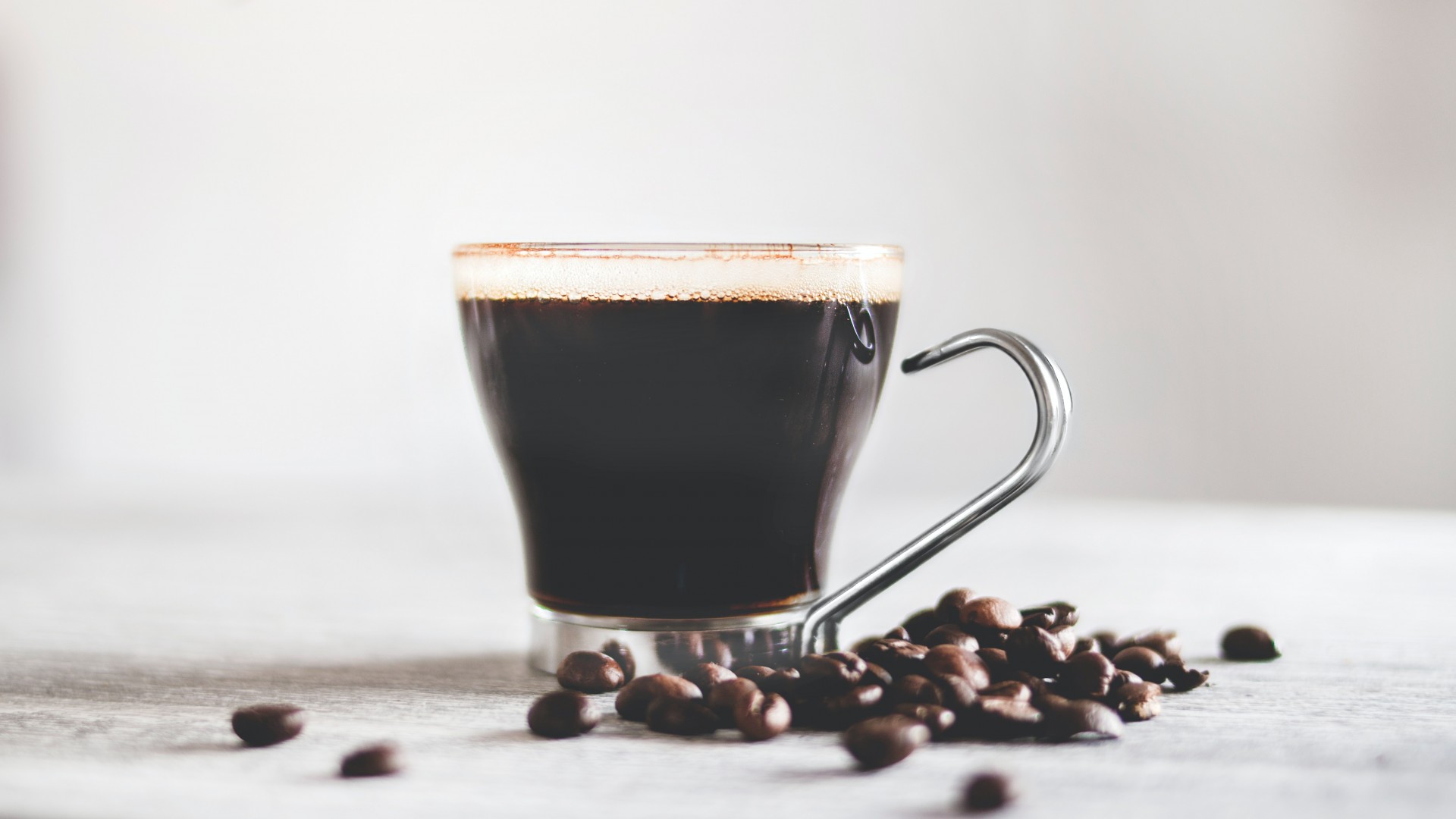 Cup of espresso with coffee beans on the table